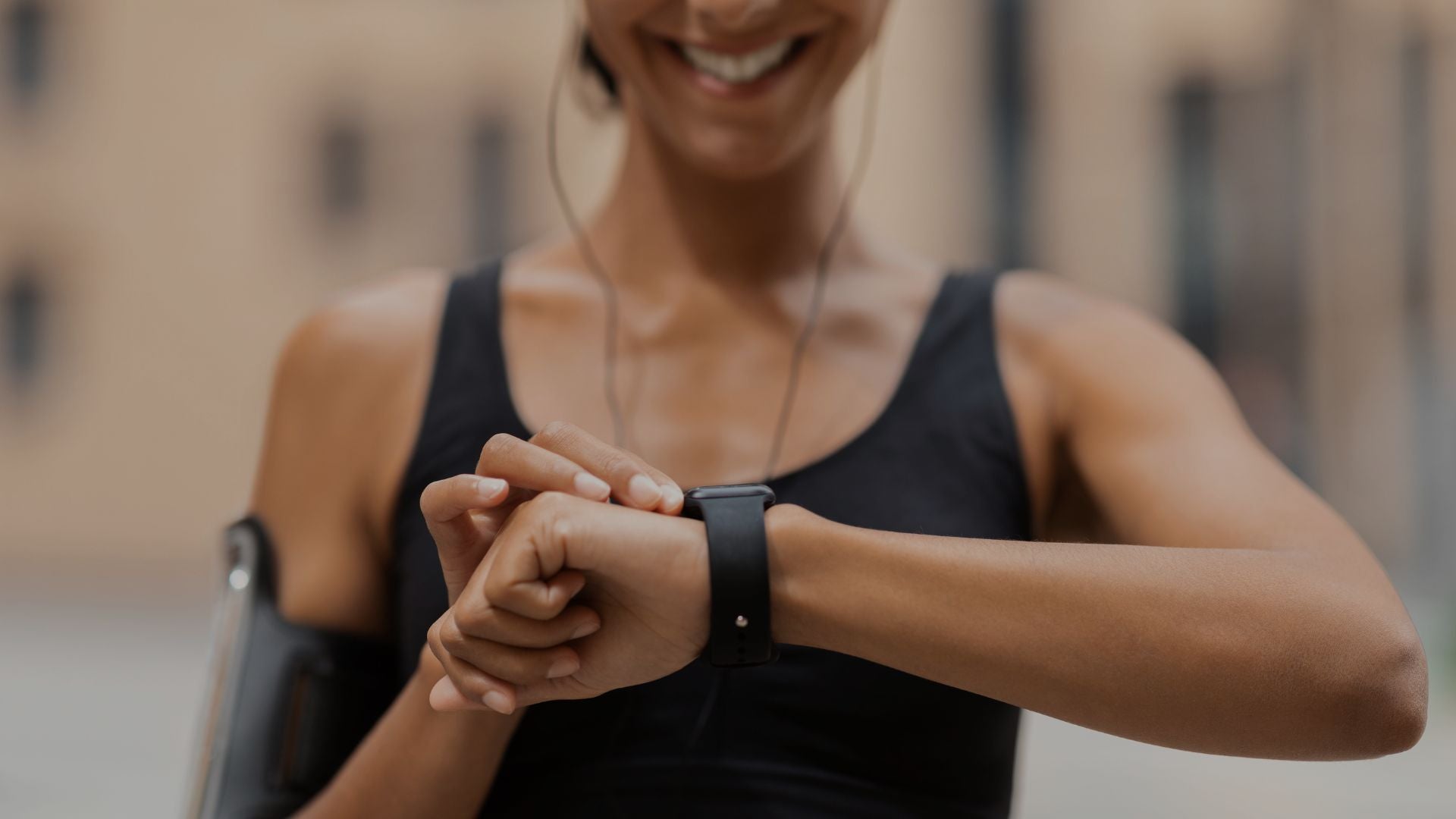 Woman checking fitness smartwatch before workout while wearing sports headphones confidently.