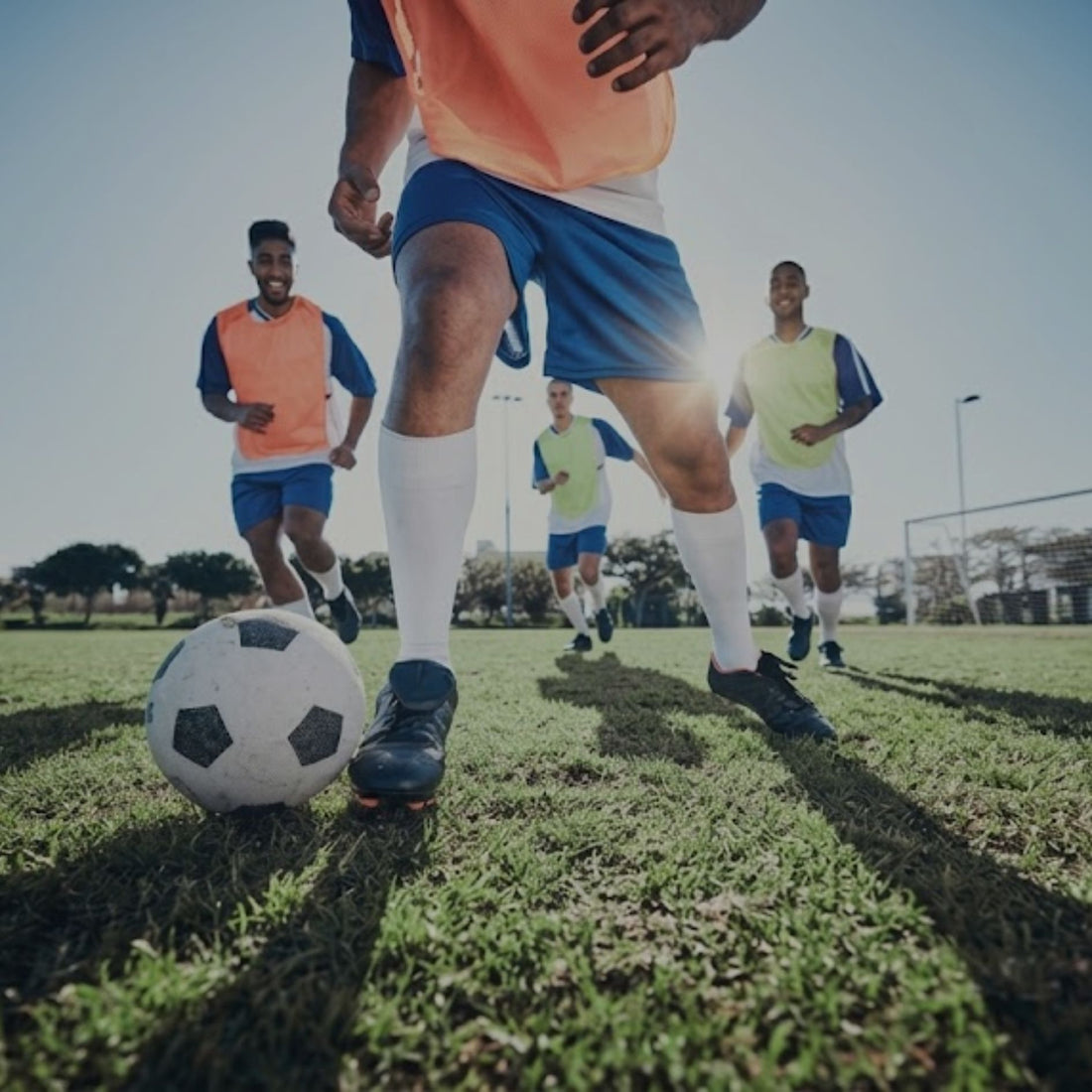 Soccer team practicing ball control during outdoor football training session together